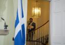 Humza Yousaf descends the staircase in Bute House ahead of a press conference