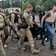 Ukrainian servicemen carry a bag containing a body after a Russian attack on the city of Zaporizhzhia. Russia last week claimed to have annexed large areas of Ukraine