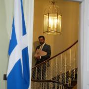 Humza Yousaf descends the staircase in Bute House ahead of a press conference