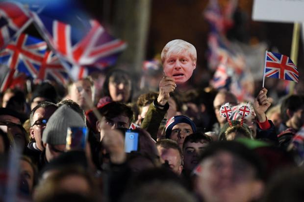 Brexit supporters wave Union flags and a mask of Boris Johnson on Brexit Day. File photo.