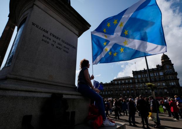The National: GLASGOW, SCOTLAND - AUGUST 31: A demonstrator waves a flag at a Stop the Coup protest in George Square on August 31, 2019 in Glasgow, Scotland. Left-wing group Momentum, remain group Another Europe is Possible and the People's Assembly coordinate a se