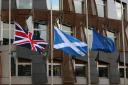 A Union flag, a Saltire flag and an European Union flag fly outside the Scottish Parliament in Edinburgh