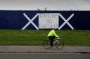 A man rides past graffiti written in Gaelic reading 'Failte Gu Partaig' (Welcome To Partick) in the Partick area of Glasgow