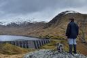 A boy and his dog view Cruachan hydro electric power station in Argyll on March 30, 2016 in Dalmally,Scotland