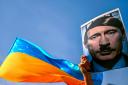 A protester holds a picture depicting Russian President Vladimir Putin as Adolf Hitler during a rally against Russia's invasion of Ukraine at Beyazid district in Istanbul