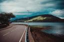 A road along the shore of Loch Fyne, home to award-winning restaurant Inver. Photo by Aleks Marinkovic on Unsplash