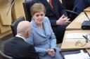 Nicola Sturgeon, right, chats with righthand man John Swinney before announcement in Holyrood today