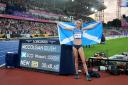 Scotland’s Eilish McColgan poses next to her Commonwealth Record after winning Gold in the Women’s 10,000m