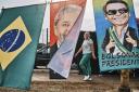 A woman walks by flags of presidential candidates Luiz Inacio Lula da Silva and Jair Bolsonaro at Feira dos Importados in Brasilia