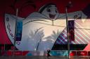 A woman walks past a large poster of mascot La'eeb in Doha ahead of the 2022 Qatar World Cup