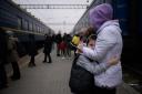 A woman hugs a child as a train prepares to leave the main railway station in Zaporijia