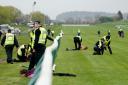 Animal Rising activists apprehended by police officers as they attempted to invade the race course during the Scottish Grand National festival