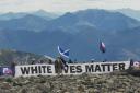 Patriotic Alternative members unfurl a 'White Lives Matter' banner at the top of Ben Nevis