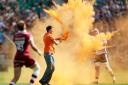 A Just Stop Oil protester throws orange paint powder over a player during the Gallagher Premiership final