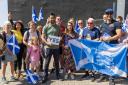 First Minister of Scotland Humza Yousaf holds a Yes sign with SNP activists during campaigning in Pollok, Glasgow
