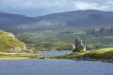 Tourists visiting 16th century Ardvreck Castle ruin at Loch Assynt in the Scottish Highlands, Sutherland