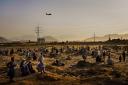 A military transport plane departs overhead as Afghans hoping to leave the country wait outside the Kabul airport on Aug  23, 2021