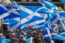 People wave Saltires at a march for Scottish independence