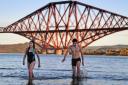 Members of the public brave cold waters in River Forth to take a New Year dip in front of the Forth Rail Bridge on January 1