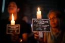 Filipino activists hold candles with slogans after saying prayers calling for an immediate ceasefire in the Middle East