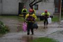 Members of the emergency services carry residents belongings to safety in Brechin