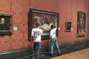 Two activists have been arrested for smashing glass protecting a painting at the National Gallery in London