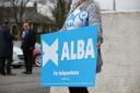 An Alba supporter holds a sign outside an Aberdeenshire polling station
