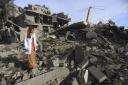 Palestinians look at destruction from the Israeli bombardment of the Gaza Strip in Rafah