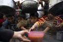 Palestinian children line up to be fed in Rafah, Gaza Strip