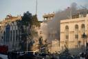 Emergency services work at a destroyed building hit by an air strike in Damascus, Syria, on Monday, April 1