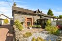 The semi-detached cottage is located in Luss