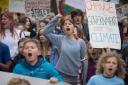 Schoolchildren take part in a 'die-in' climate change protest campaigning against the use of fossil fuels