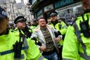 Metropolitan Police officers arrest British far-right activist Tommy Robinson during a demonstration in central London