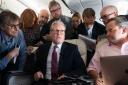 Prime Minister Keir Starmer talks to the media on board his plane as he flies to Washington DC