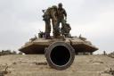 Israeli army soldiers are positioned with their Merkava tanks near the border with the Gaza Strip in southern Israel