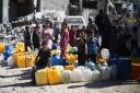 Palestinians queue to fill cans with water in southern Gaza