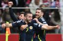 John McGinn celebrates his goal against Poland in the Nations League match in Warsaw tonight with his Scotland team mates