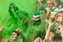 A Celtic fan holds up a flare