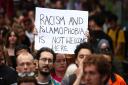 A woman holds aloft an anti-Islamophobia sign at a protest