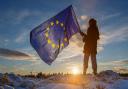 A young girl holds an EU flag as the sun sets at Eaglesham Moor near Glasgow, Scotland.  Photograph by Colin Mearns.