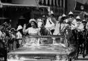 18th February 1966:  The Queen and Prince Philip driving through Barbados waving to the crowds.  (Photo by Keystone/Getty Images).