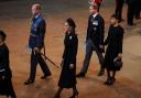 Prince William, Prince of Wales, Catherine, Princess of Wales, Prince Harry, Duke of Sussex and Meghan, Duchess of Sussex walk as procession with the coffin of Britain's Queen Elizabeth arrives at Westminster Hall