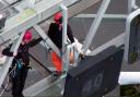 A specialist police officer, trained to work at heights working to remove a protester from the gantry over junction 30 of the M25