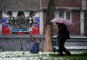 A pedestrian walks past a defaced mural to the glory of Russia's mercenary group Wagner