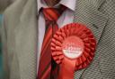Stock image of a Labour candidate wearing a red rosette