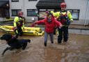 A member of the emergency services helps resident Laura Demontis from a house in Brechin