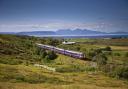 Super Sprinter train passes islands of Eigg and Rhum on the Fort William to Mallaig Line