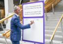 Liam McArthur signs a pledge card in support of his Assisted Dying Bill, at the Scottish Parliament