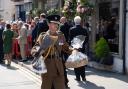 The King's equerry carries baskets of treats and flowers given to the King by well-wishers