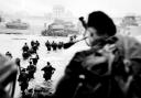 Piper Bill Millin plays his bagpipes, as Allied troops wade through the sea to the Normandy shore during the D-Day landing of June 1944